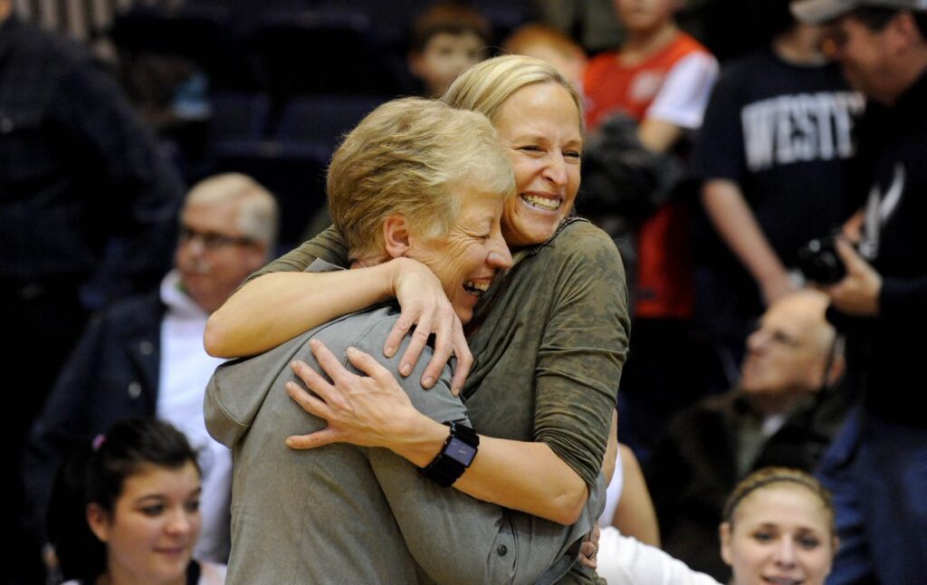 Lynda Goodrich and Carmen Dolfo hugging during the volleyball match.