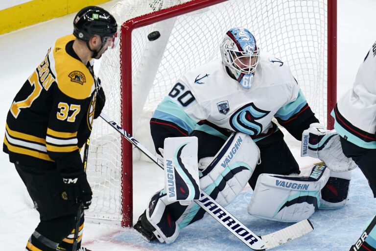 Seattle Kraken goaltender Chris Driedger (60) looks for the shot as the puck sails over his shoulder for a goal by Boston Bruins right wing David Pastrnak during the second period of an NHL hockey game