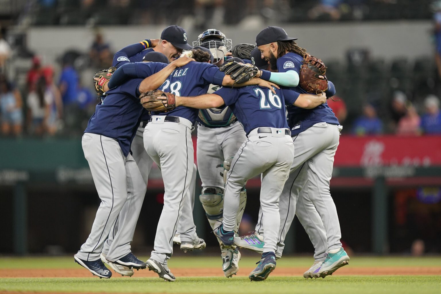 The Seattle Mariners dance in a circle after the final out of the baseball game against the Texas Rangers in Arlington