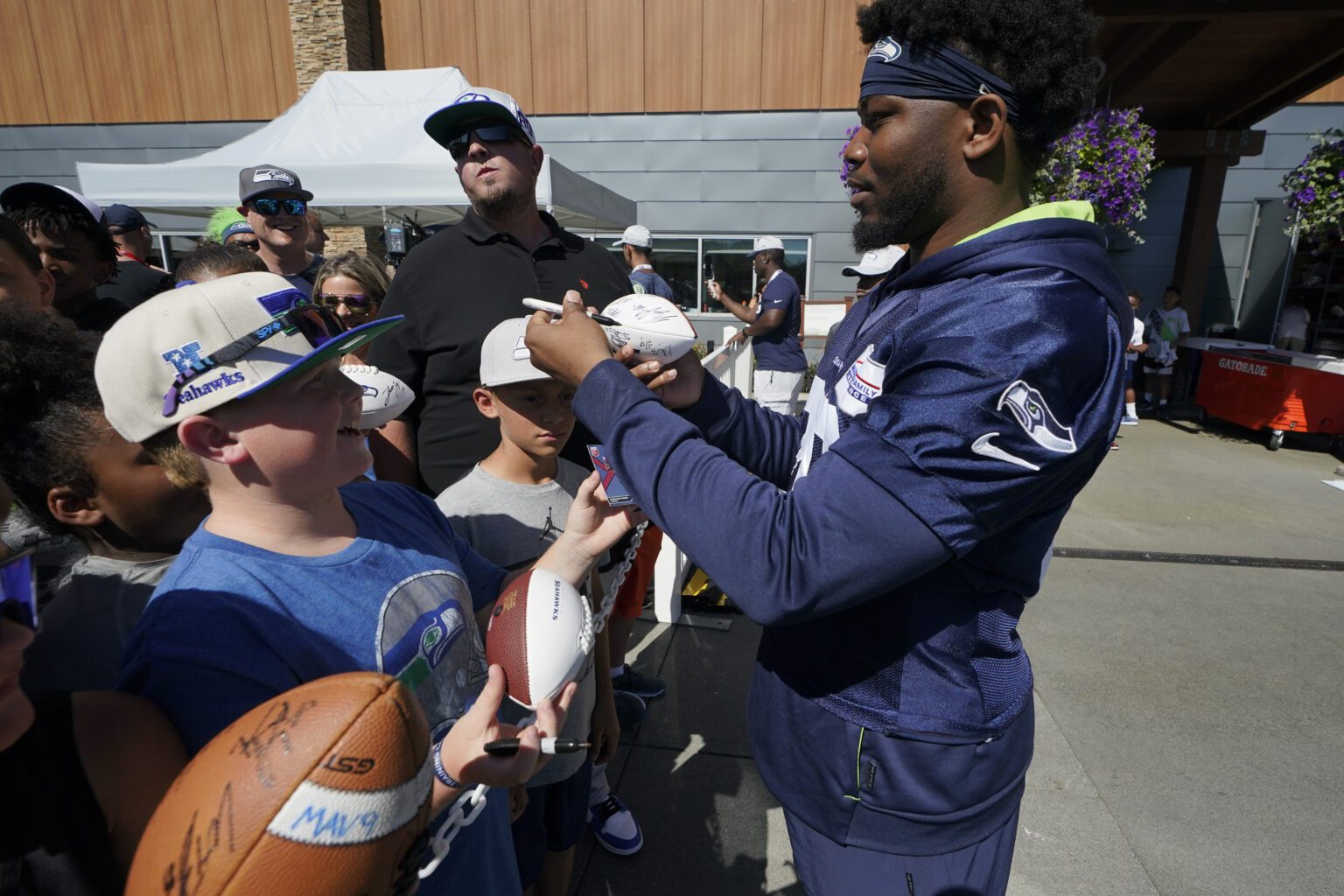 Seattle Seahawks running back Rashaad Penny signs autographs for fans after NFL football practice Aug. 3 in Renton.