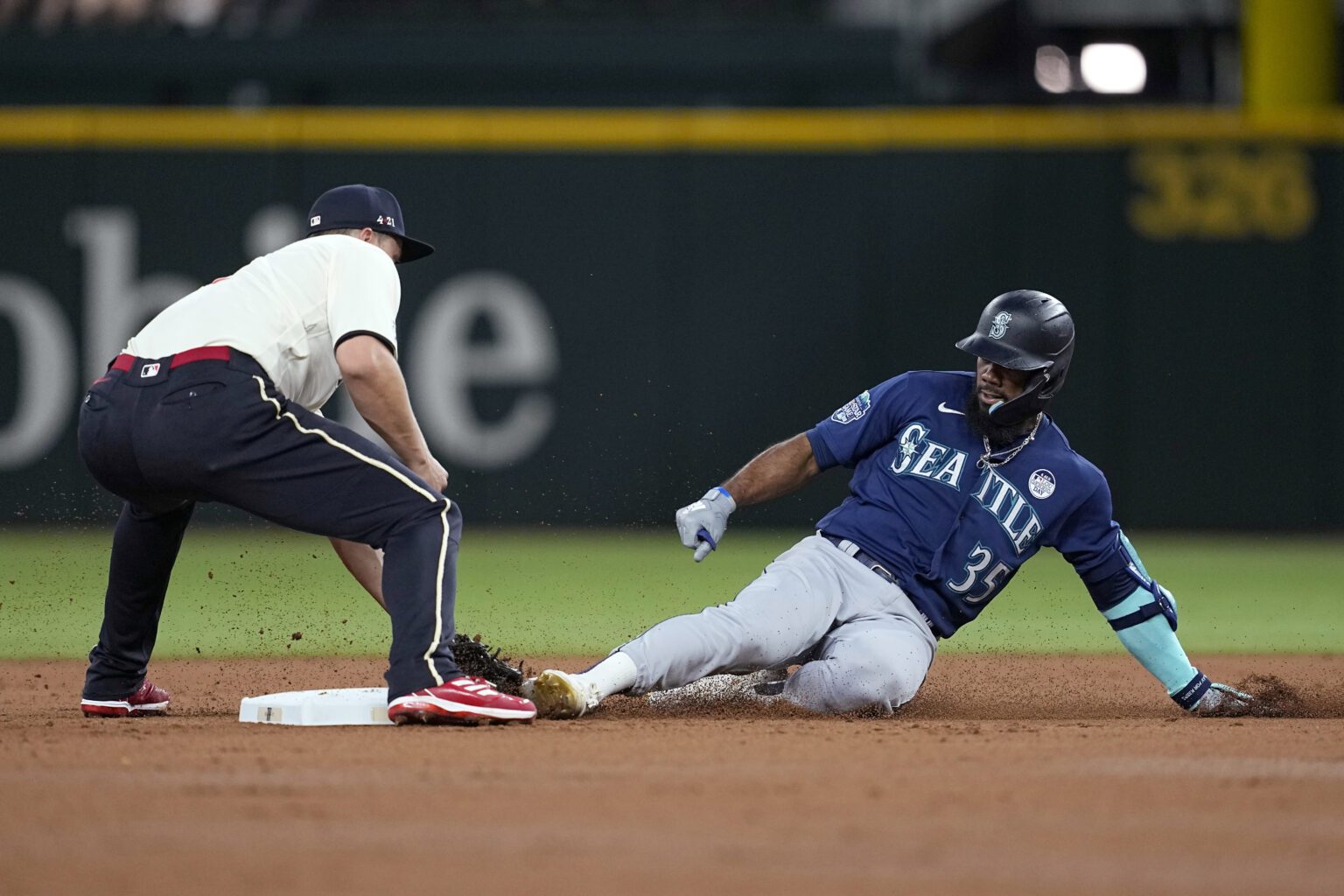 Texas Rangers shortstop Corey Seager, left, reaches down to tag out Seattle Mariners' Teoscar Hernandez (35).