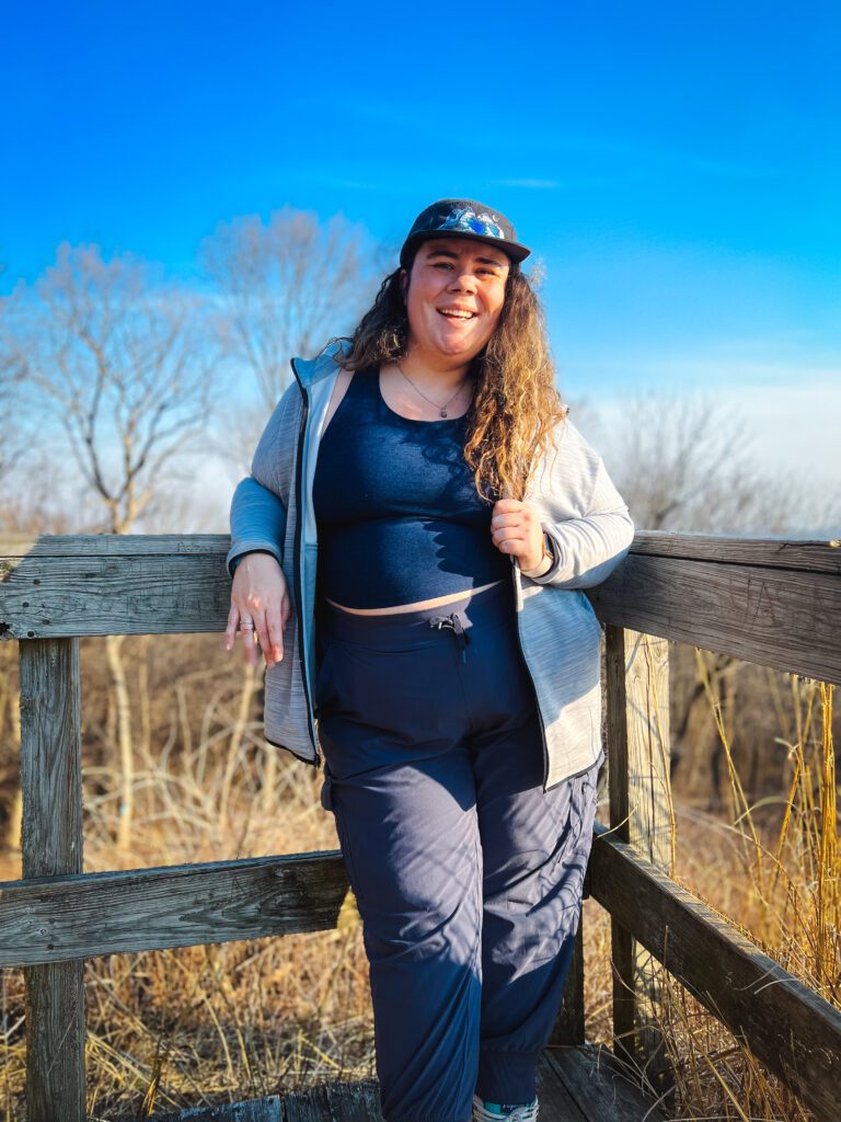 Molly Kelly leaning against a wooden fence in Pere Marquette State Park, Illinois.