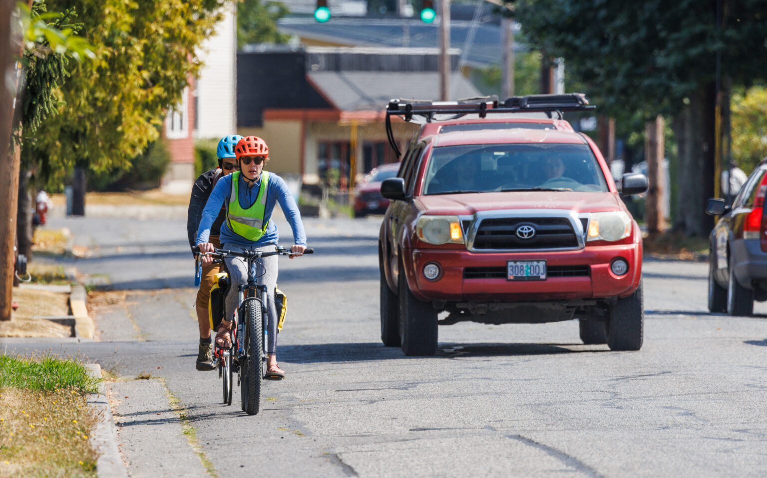 Two bicyclists pedal in a single file up Eldridge Avenue on Sept. 3. Some Eldridge residents oppose a proposal to remove street parking to make room for bike lanes.