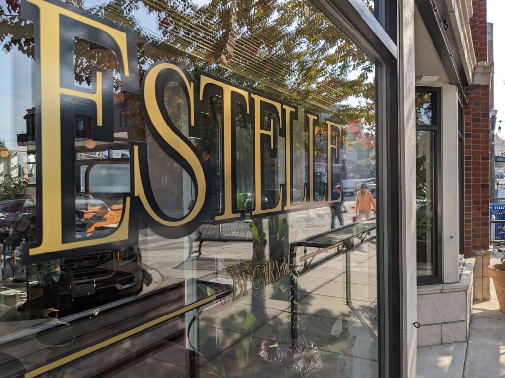 Bistro Estelle's window showcasing the store's name in bright yellow font.