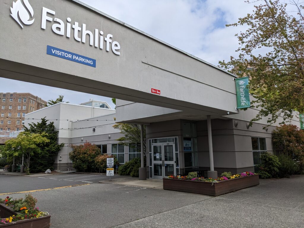A building has two "Faithlife" signs on it as well as "Visitor Parking."
