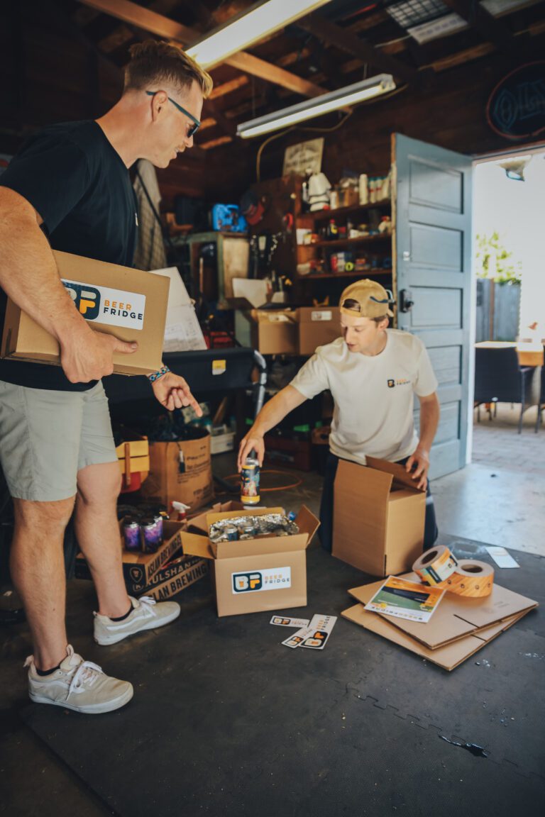 Beer Fridge founders Travis Kane (left) and Jake Bassett fill curated craft beer boxes. The Bellingham locals started the business in 2021 and began shipping this March.
