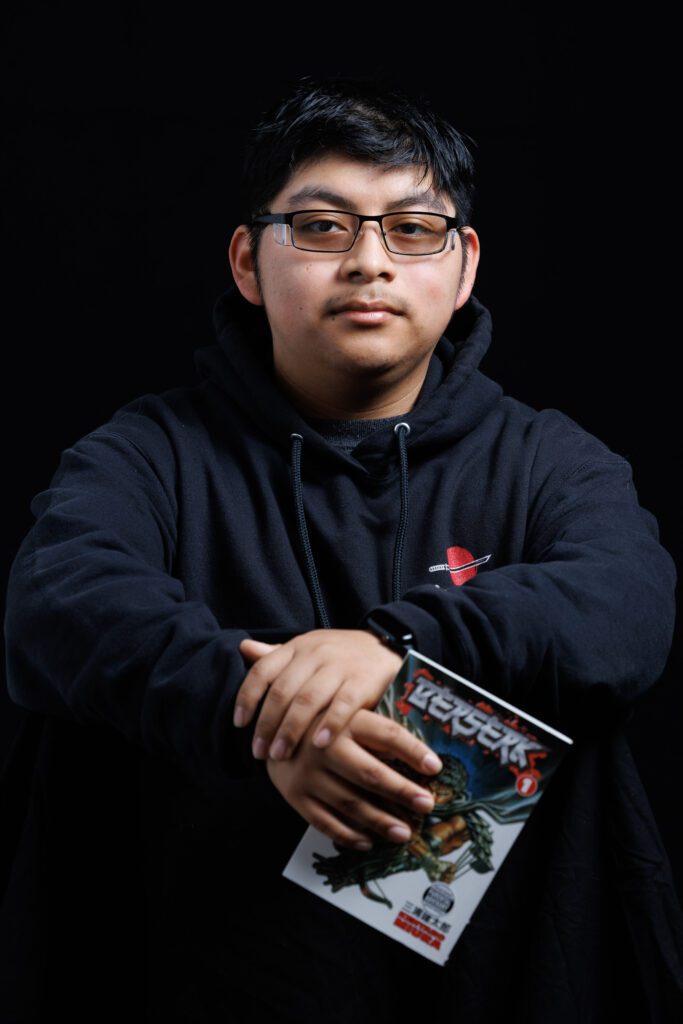 A photo of Jorge Mendoza holding a Berserk manga.