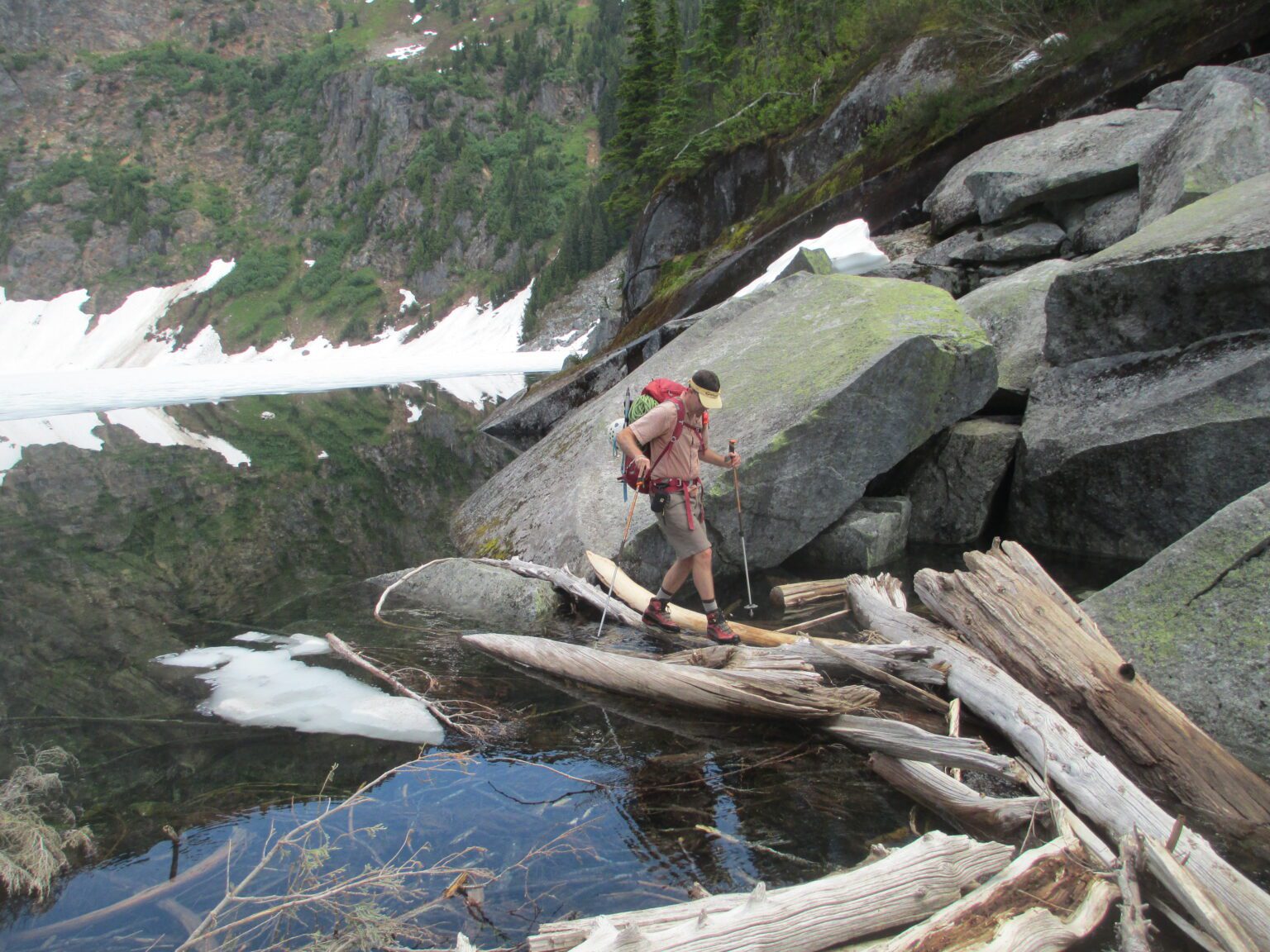 Backpacker Dave Zulinke crosses a log jam at Thornton Lake. Backcountry adventurers are increasingly adding the threat of human violence into calculations about outdoor activities. Crime in wilderness and backcountry areas is rare