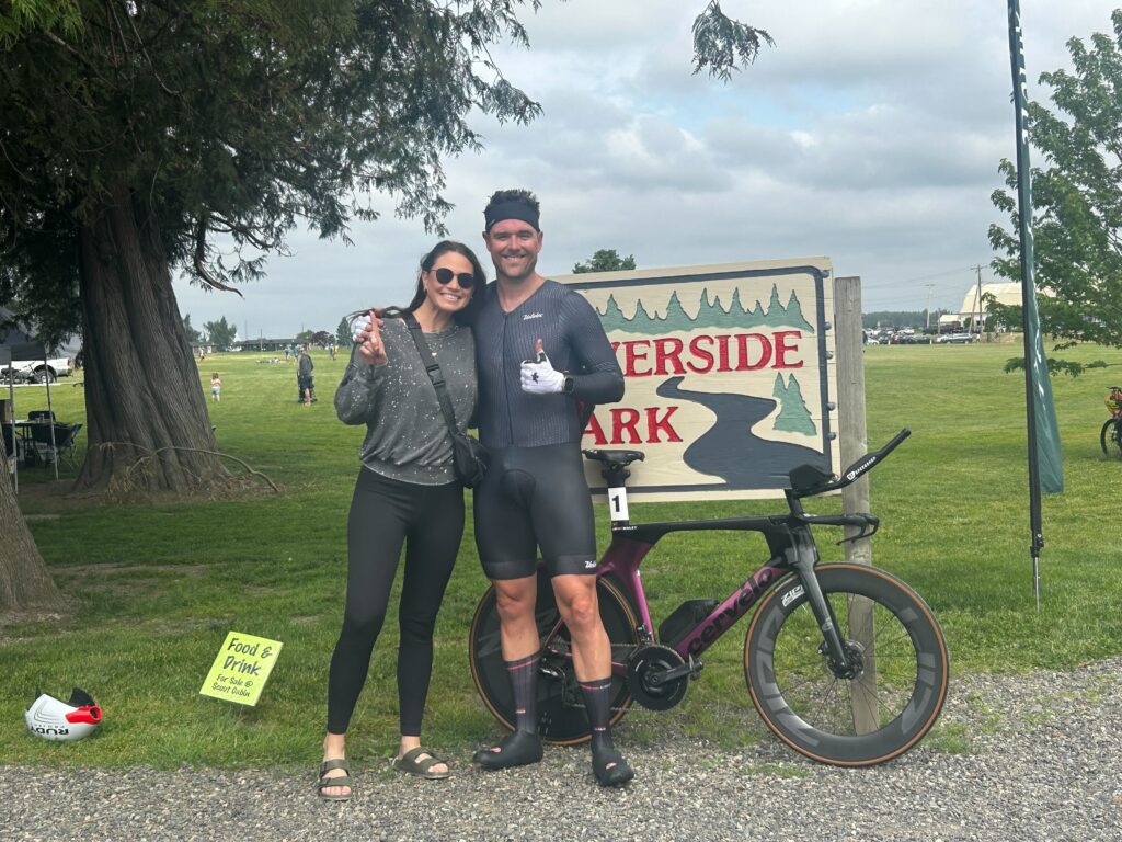 Matt Bailey poses by the Riverside Park sign with his wife, Kayla Bailey.