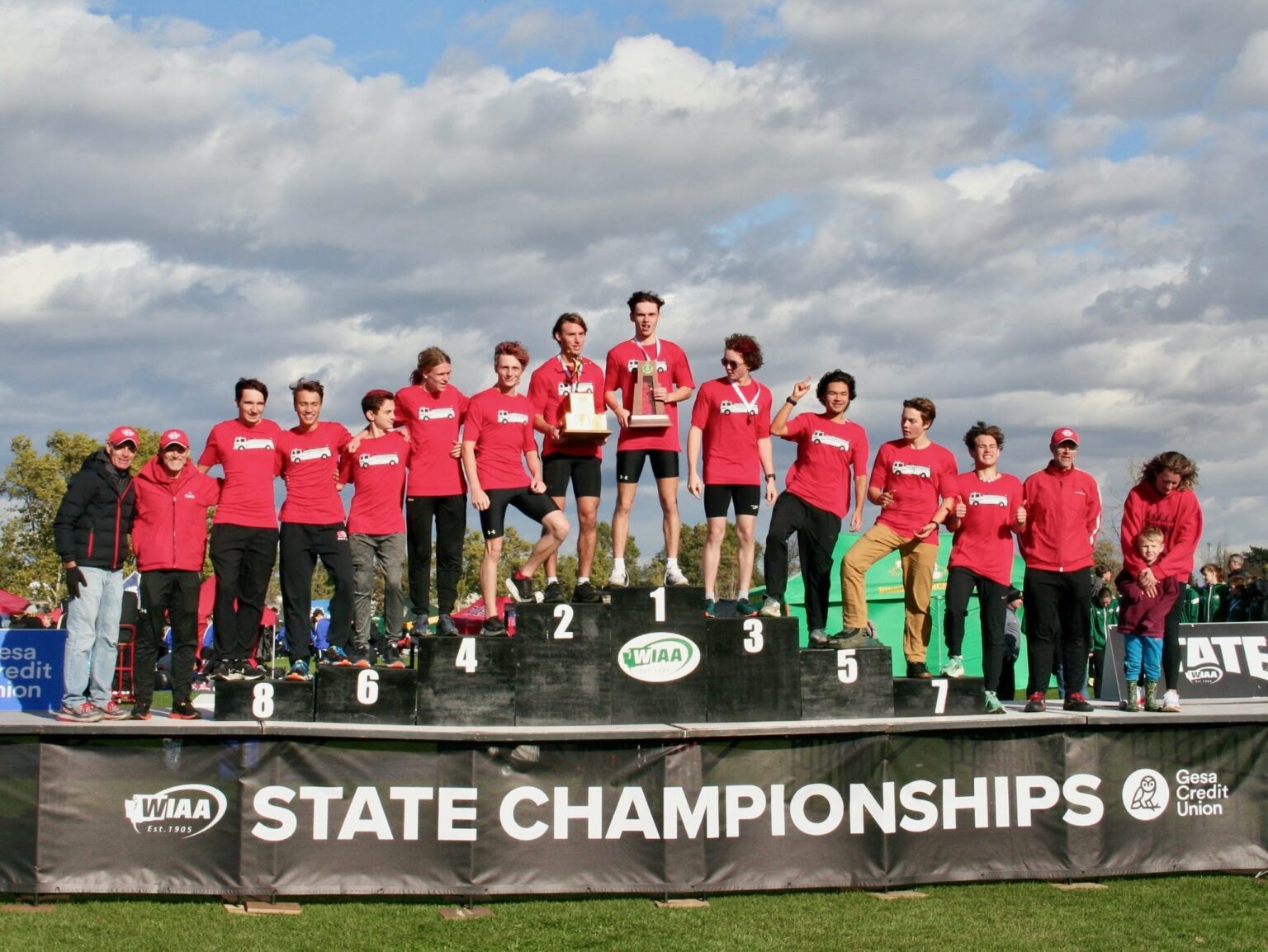 The Bellingham boys cross country team poses on the podium with their 2A state championship trophy at the WIAA 2A boys state cross country meet on Nov. 5 at Sun Willows Golf Course in Pasco