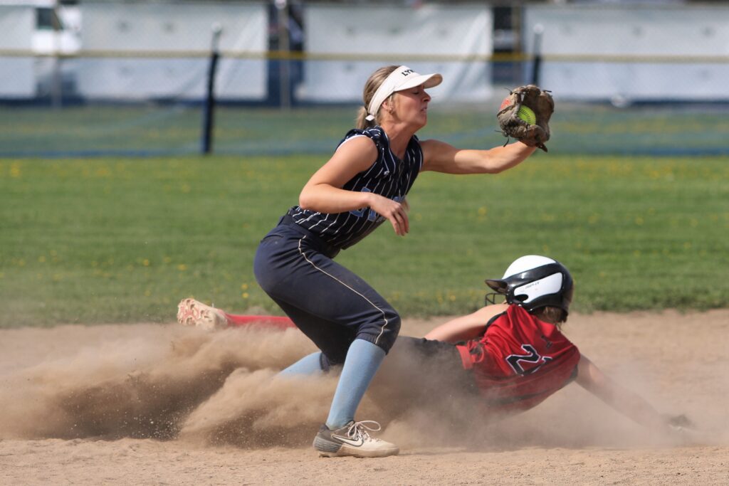 Mount Baker's Lauren Valum slides into second base just as the catch is made with the catchers eyes closed as the dust from the ground flies up from the slide.