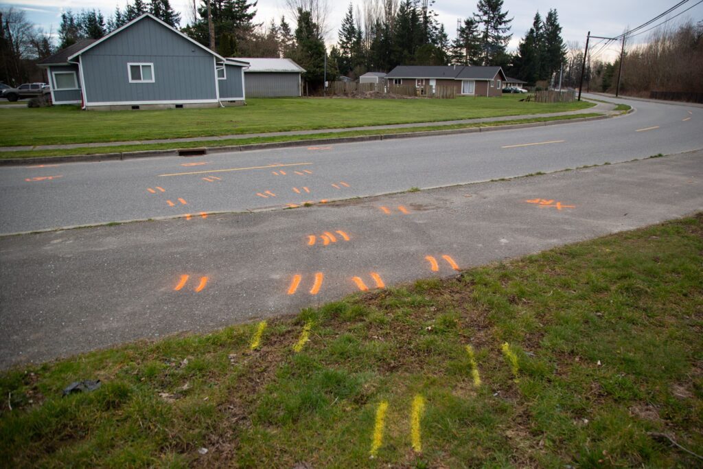 Tire tread impressions and spray paint left by police investigators mark David Babcock's route before he was shot and killed by a Sedro-Woolley police officer last February
