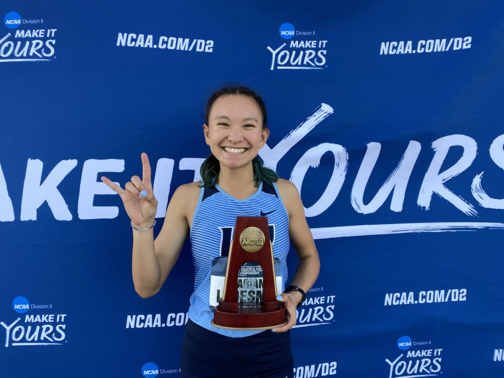Marian Ledesma holds a trophy as she poses for a photo.