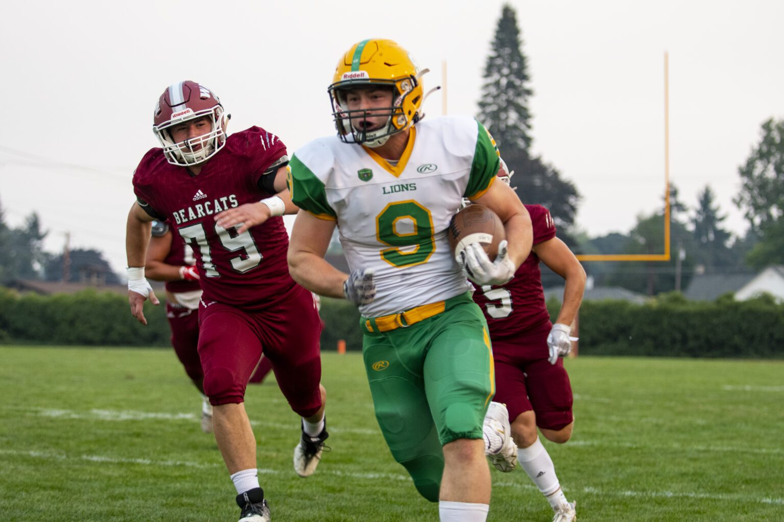 Lynden running back Campbell Nolte (9) takes off down the sideline as players from the opposing team chase him from behind.