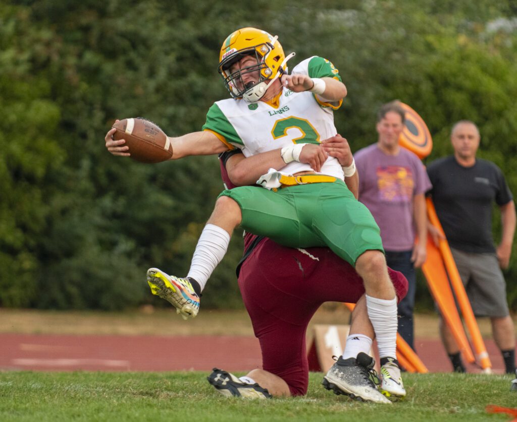 Lynden quarterback Kaedan Hermanutz (3) reaches across the goal line for a touchdown but gets grabbed by the waist by the opposing player.