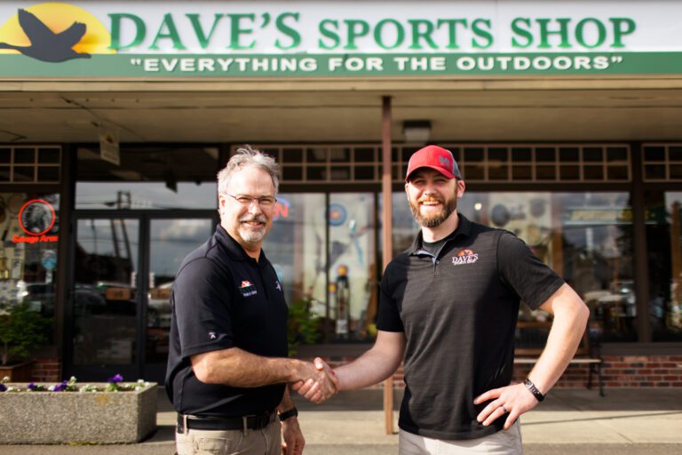 Dave VanderHoek and Will Lathrop shake hands outside Dave's Sports Shop