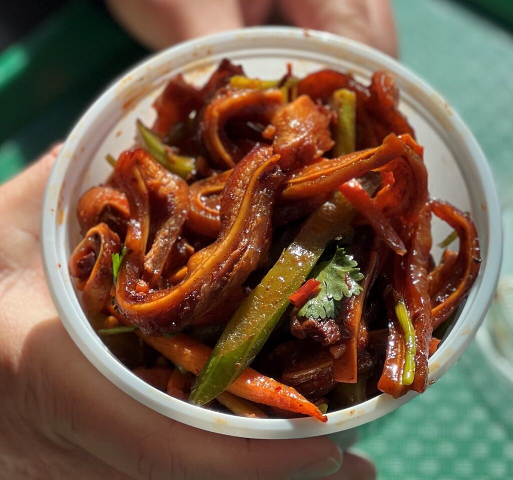 A bowl of spicy pig's ears stir fried with vegetables and spices.