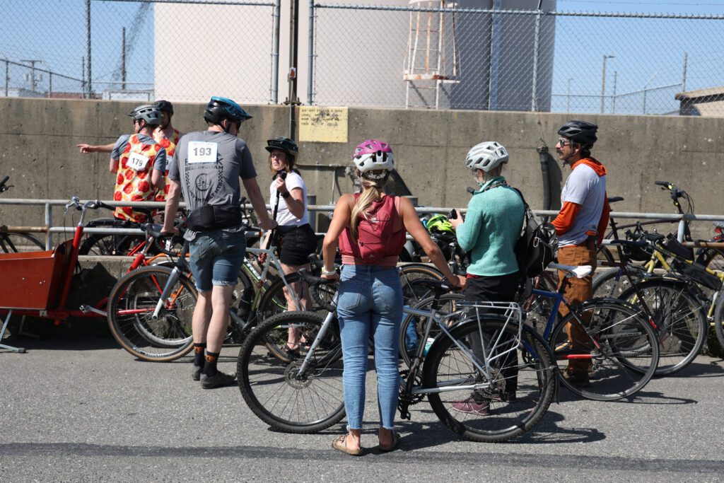 A group of cyclist look for spots to secure their bicycles near the finish line.