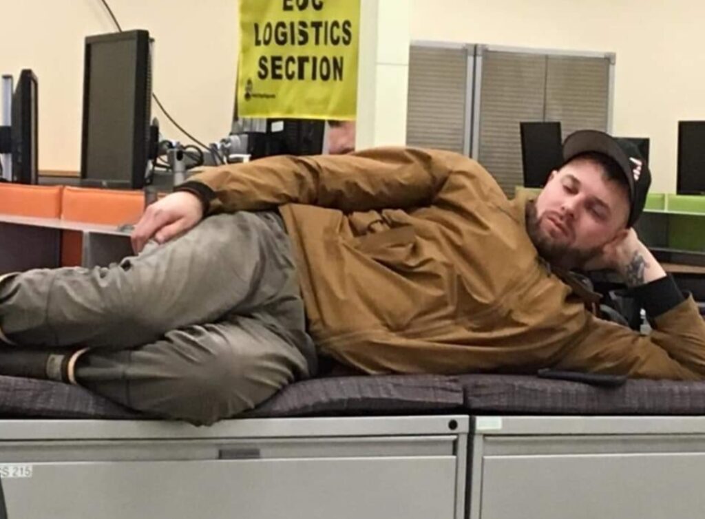 A man laying on top of filing cabinets.