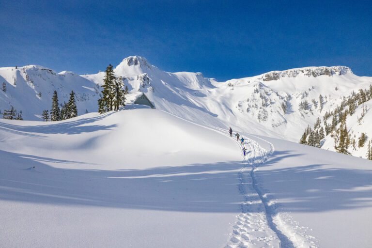 Snowshoers in March follow the deep tracks past the Heather Meadows Visitor Center on their way to Artist Point.