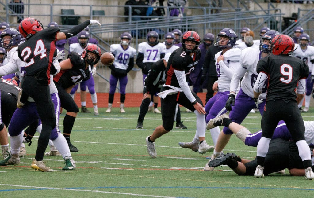 Nooksack Valley's Jorgen Vigre (8) watches his kick get blocked in the middle of both teams as others watch from the sidelines for the result.