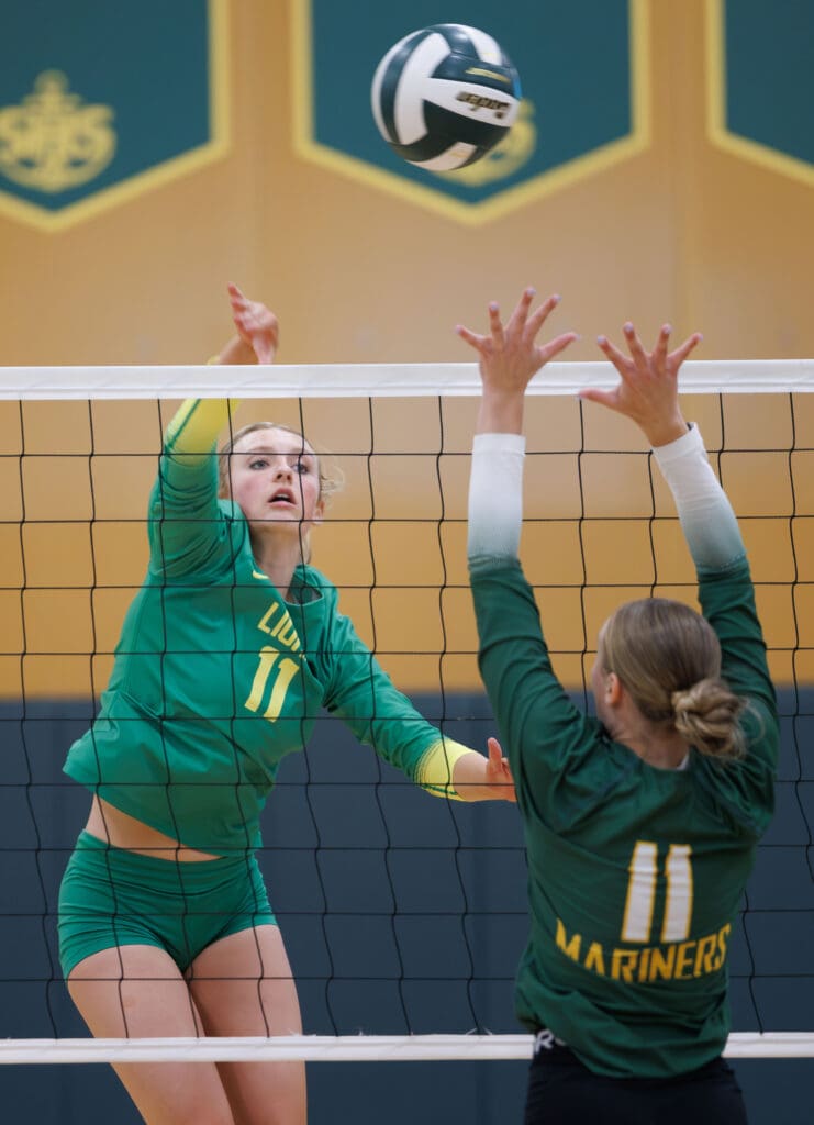 Lynden's Rian Stephan spikes the ball over the net and past the Sehome defender.