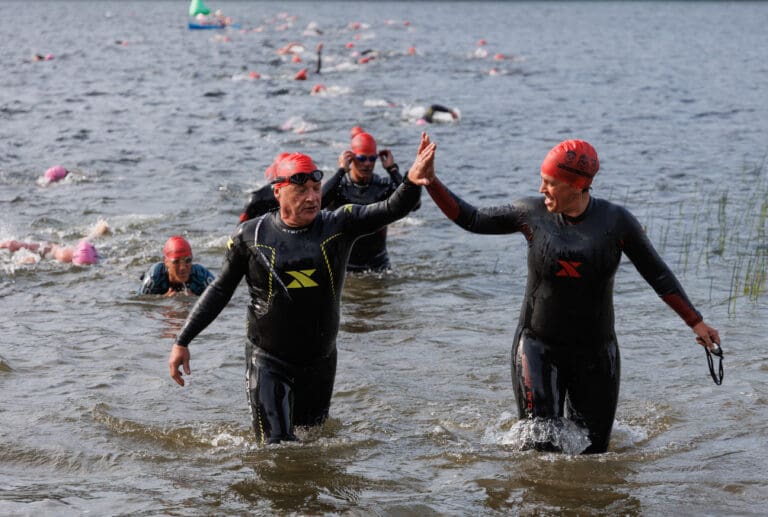 Racers high-five as they exit the water Saturday
