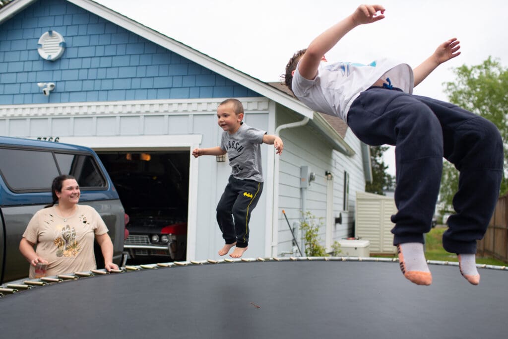 Allison Hampton watches her sons Coleson and Maximus jump on the trampoline next to her home.