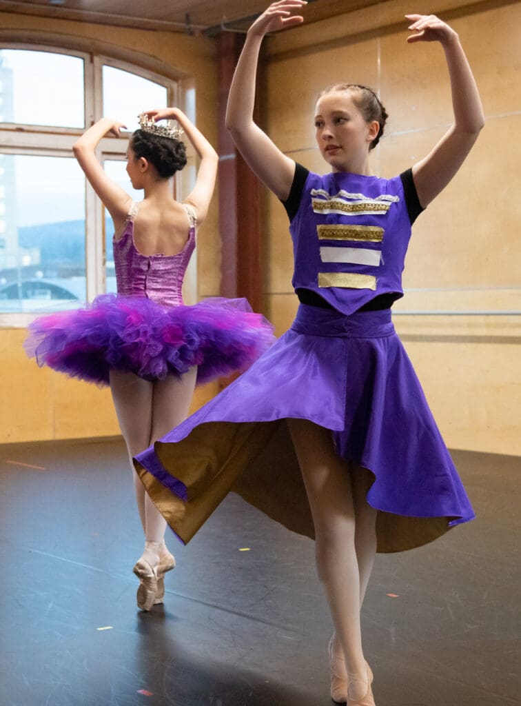 Emery Ewing as the Nutcracker and Jina Thomson as the Sugar Plum Fairy practice in their respective purple outfits.