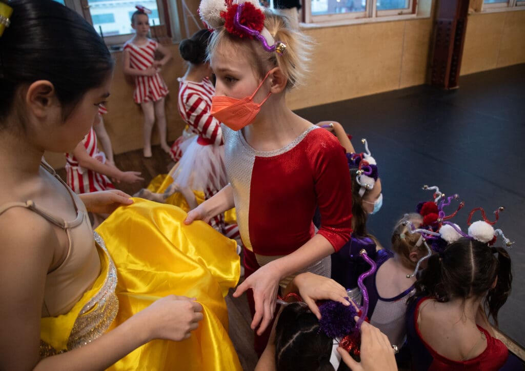 Young dancers converse in their colorful costumes.