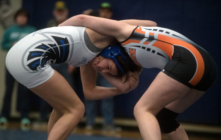 South Whidbey's Kaylie Baker and Blaine's Lucyanna Dahl wrestle with one another as they grab onto each others back and shoulders.