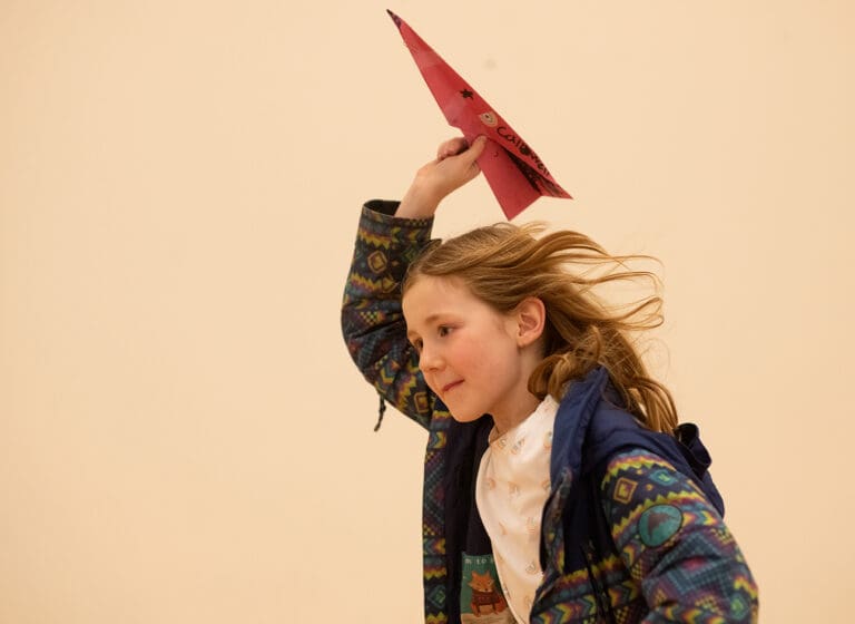 Frey Caldwell gets a running start before launching her airplane Feb. 4 during the first paper airplane derby at the Pioneer Pavilion Community Center in Ferndale.
