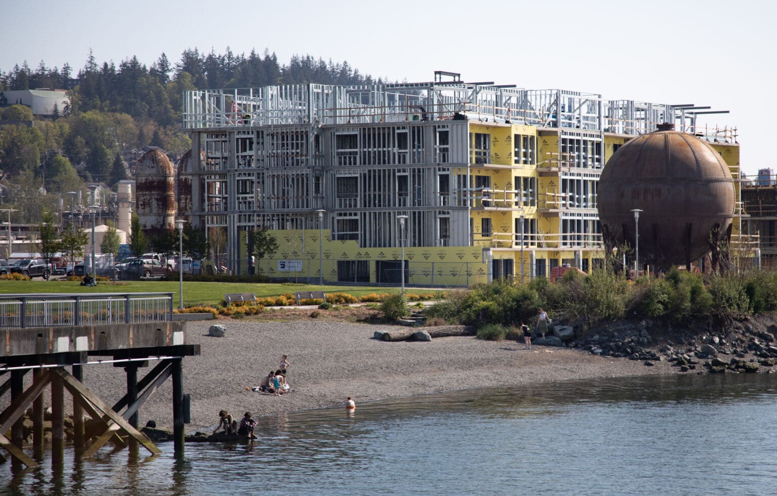 People enjoy the sunshine at Waypoint Park in May 2023. Three condominium buildings are under construction by Harcourt Developments on the waterfront. A later project will transform the historic brick Boardmill Building into a hotel