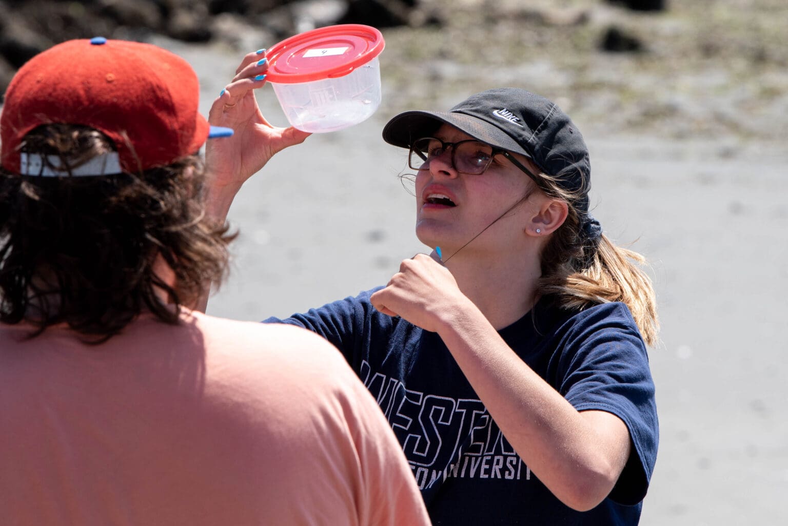 RE Sources intern Hannah Miller examines a group's collection of microplastic June 8 at H Street Beach. Miller organized a microplastic collection event