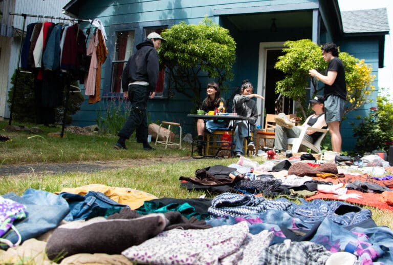 A group hosting a weekend yard sale in the Sehome neighborhood of Bellingham waits for its next customer June 18.