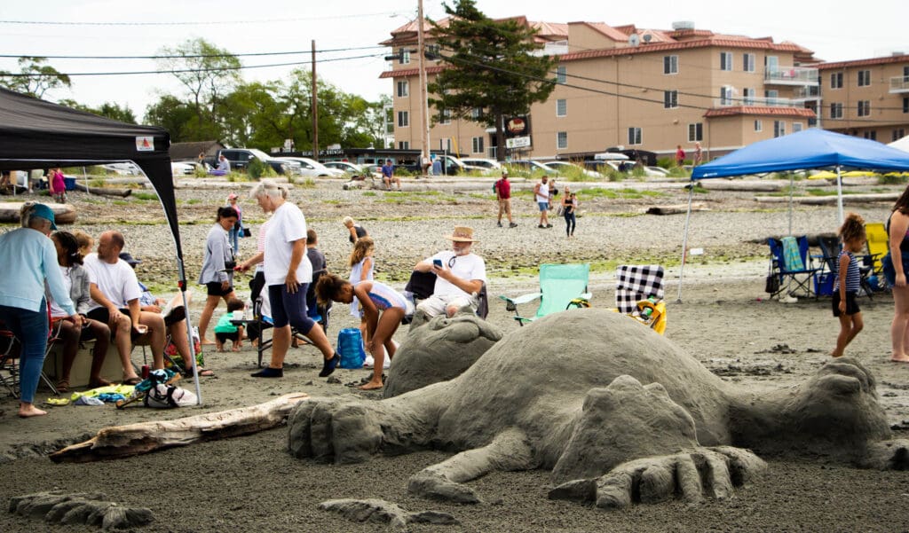 A crowd mills around Sharon and Mark Butler's cat sand sculpture.