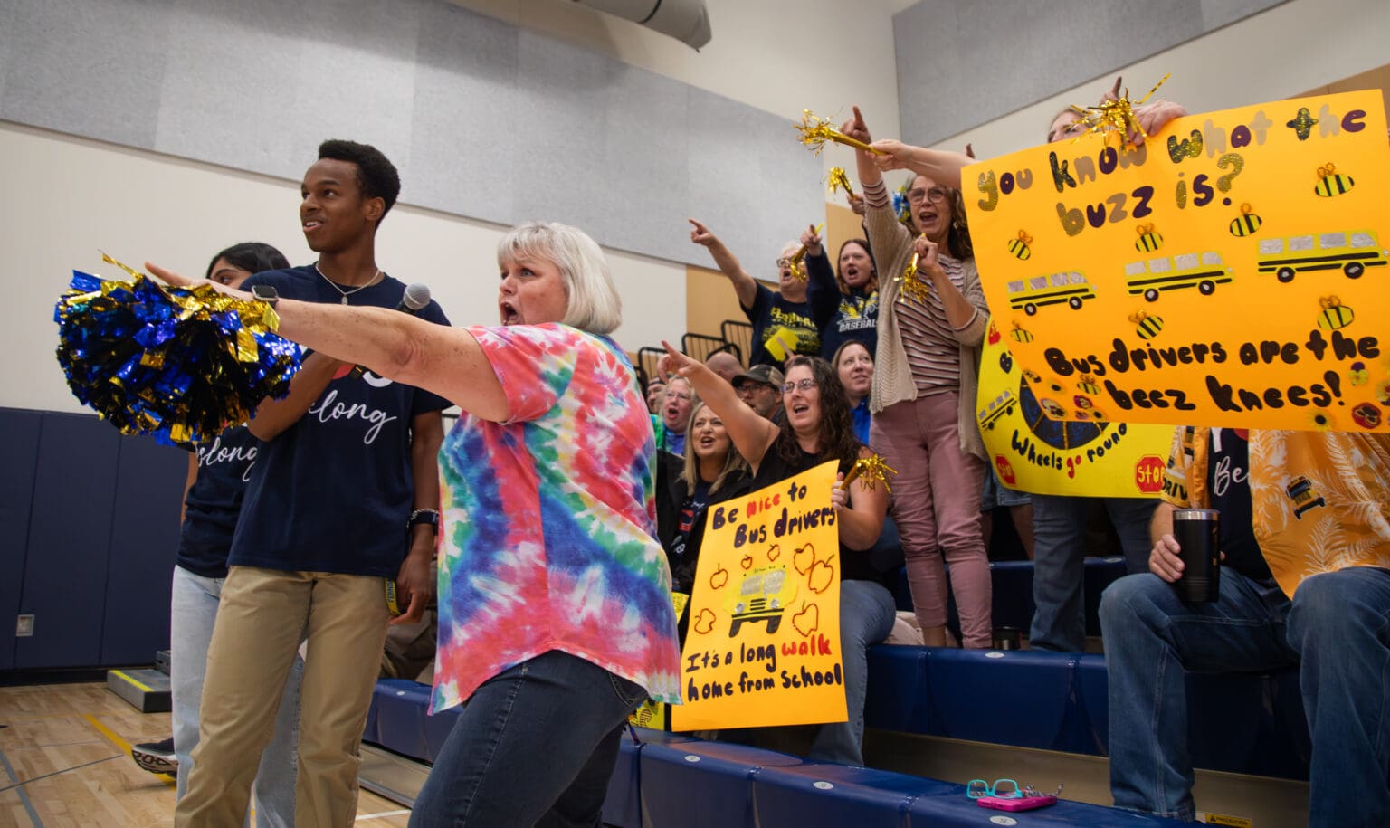 Ferndale Student School Board member Kwabena Ledbetter holds the microphone for bus driver Carla DeSoto as she cheers at the Ferndale School District staff rally at the high school on Tuesday