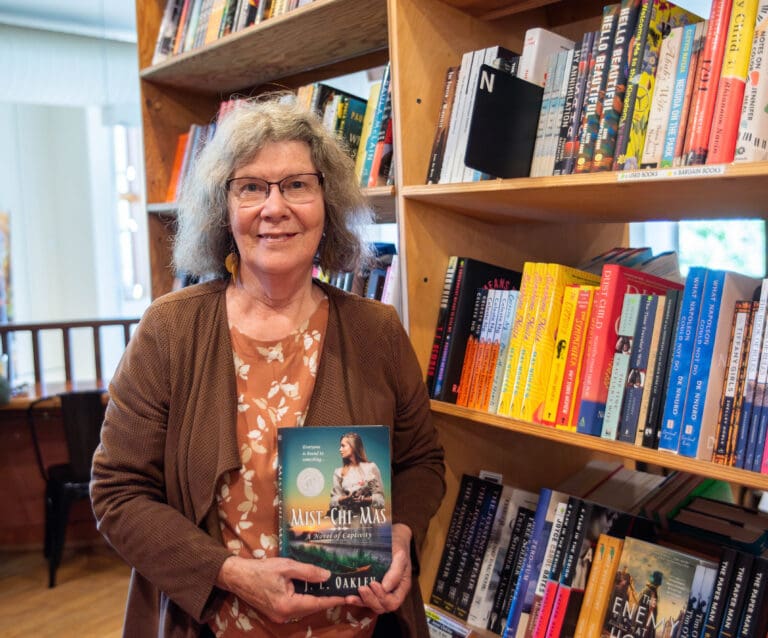 Janet Oakley holds a copy of her book "Mist-Chi-Mas" at Village Books in Fairhaven. Oakley