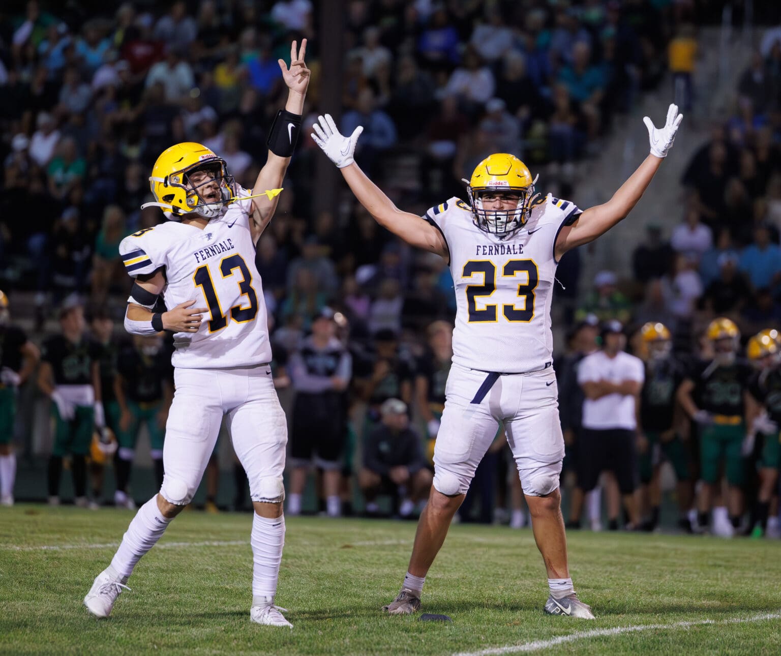 Ferndale kicker Phoenyx Finkbonner (23) celebrates his game-winning kick with teammate Bishop Ootsey with their arms stretched upwards.