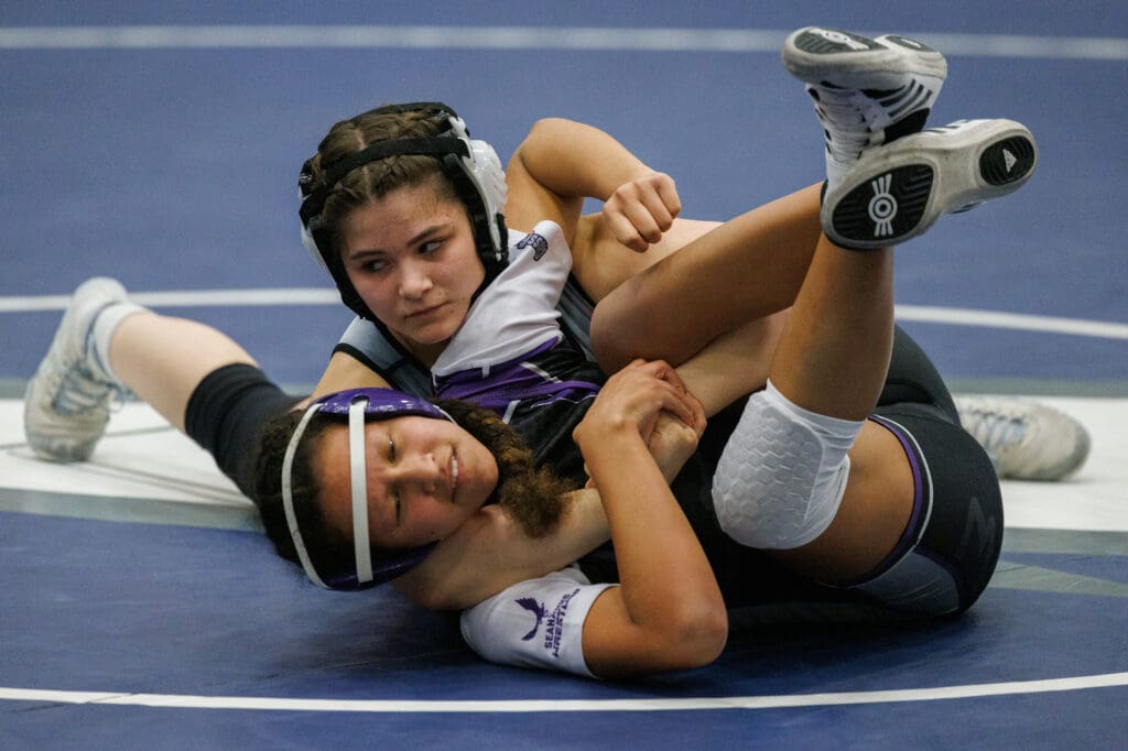 Blaine's Melania Rodriguez pins her opponent in a cradle on the blue wrestling mat.