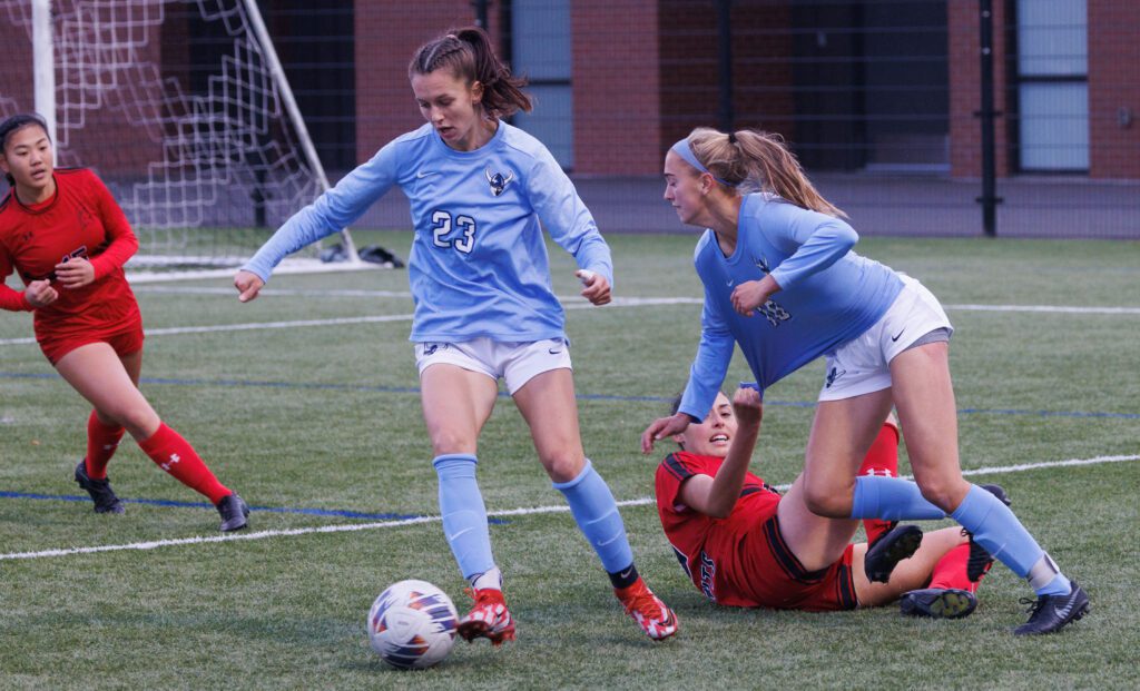 In a very physical game, Western Washington University’s Claire Potter gets pulled down by her jersey by the opposing player who is left on the ground.