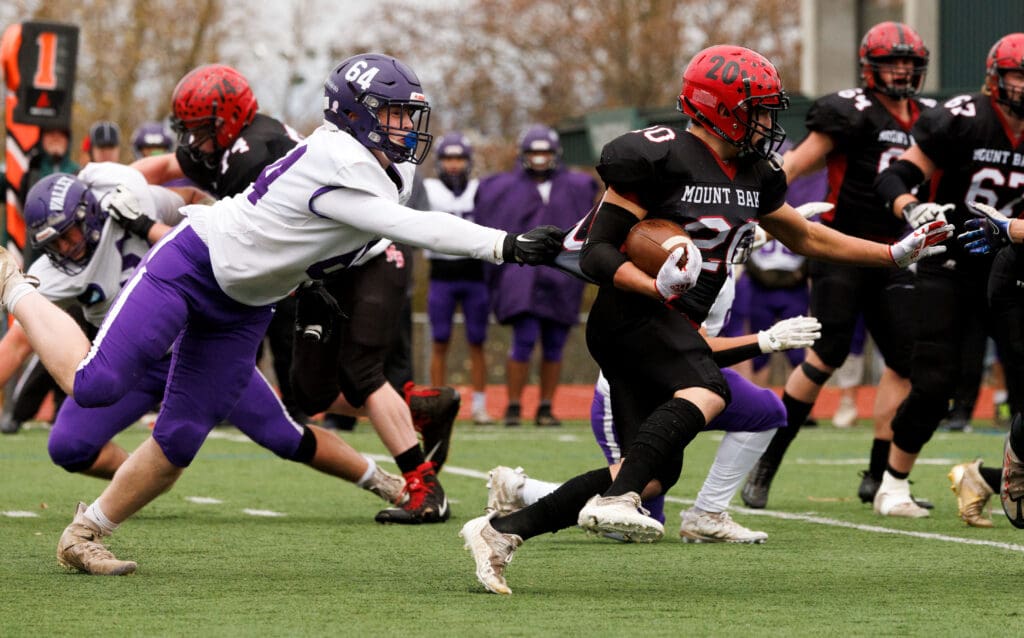 Nooksack Valley's Brady Ackerman slows down Mount Baker's Wilhelm Maloley by grabbing the back of his jersey as other players try to stop him from reaching Wilhelm Maloley.