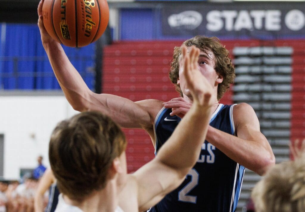 Lynden Christian's Dawson Bouma looks to the basket a he gets a layup while opposing team members turn to block him.
