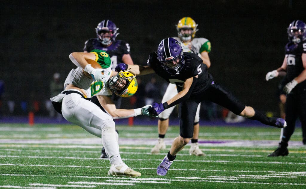 Lynden's Isaiah Stanley gets grabbed by the helmet and wrist by Anacortes sophomore Brady Beaner during a scuffle for the control of the ball.
