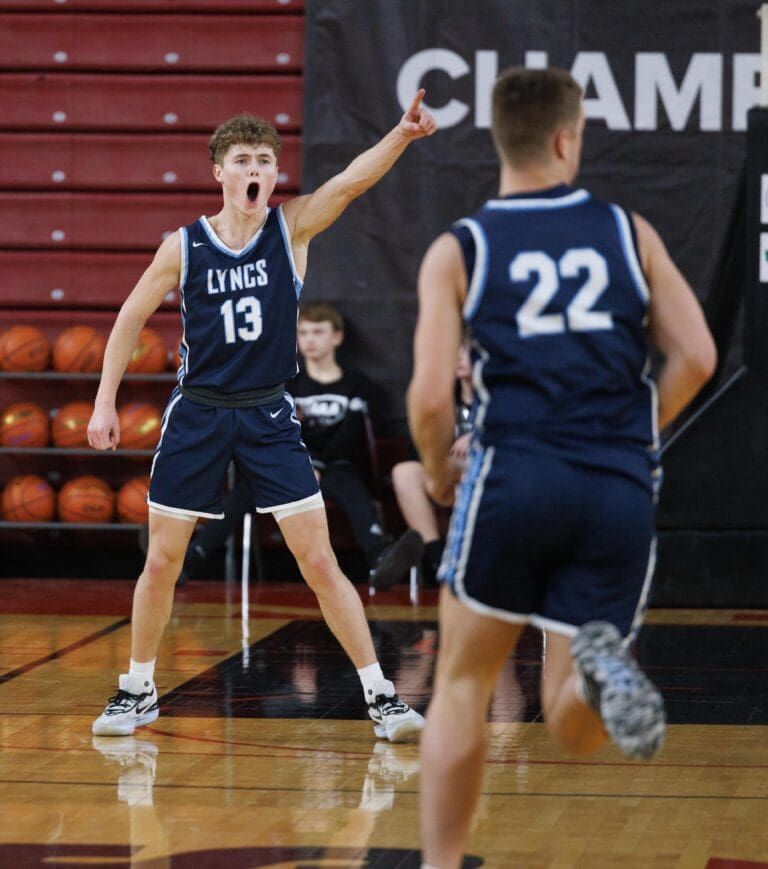 Lynden Christian’s Griffin Dykstra points a finger to the basketball net as he yells at another teammate after sinking a 3-pointer.