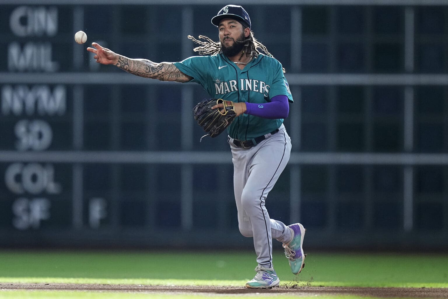 Seattle Mariners shortstop J.P. Crawford lifts a leg as he pitches the ball.