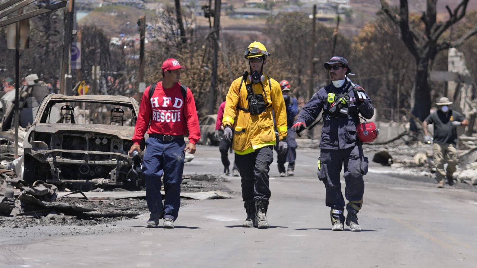 Members of a search-and-rescue team walk along a street Saturday