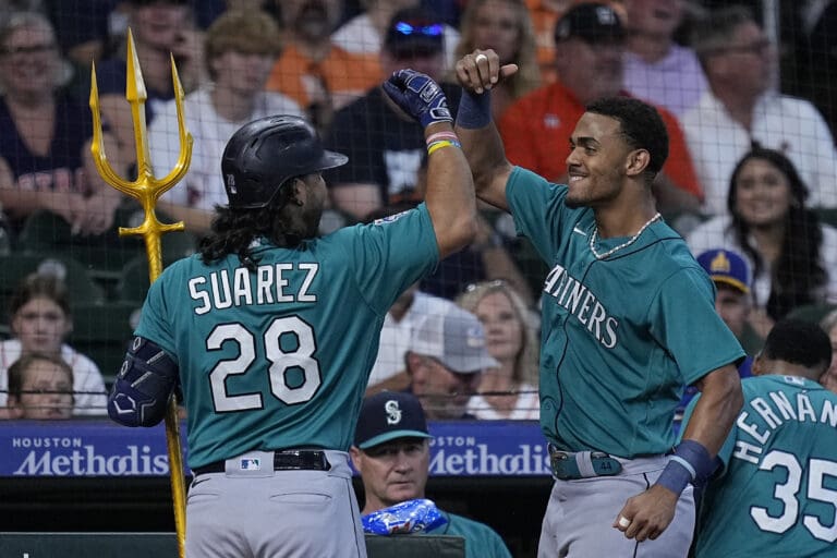 Seattle Mariners' Eugenio Suarez celebrates with Julio Rodriguez after hitting a two-run home run Sunday