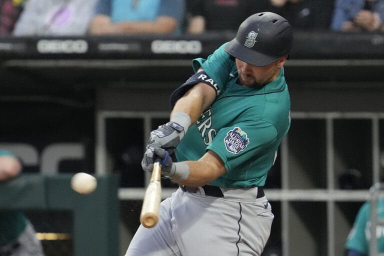 Seattle Mariners' Cal Raleigh hits a two-run double as he swings the bat against the ball.