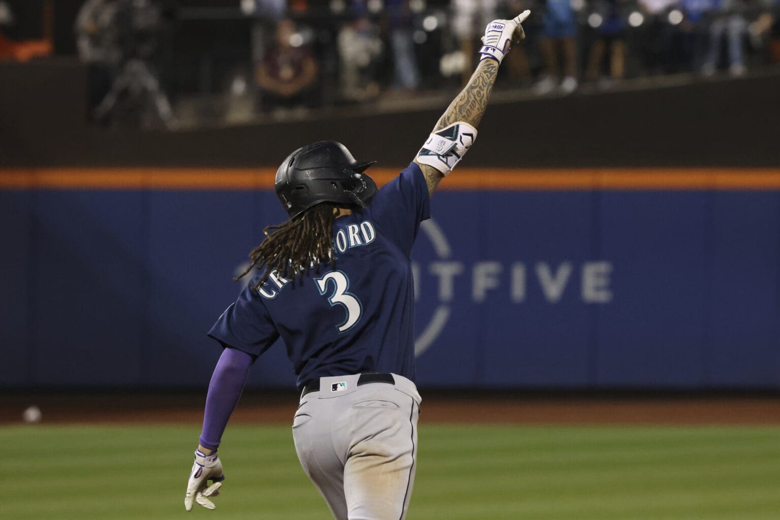 Seattle Mariners' JP Crawford celebrates as he points upwards towards the sky.